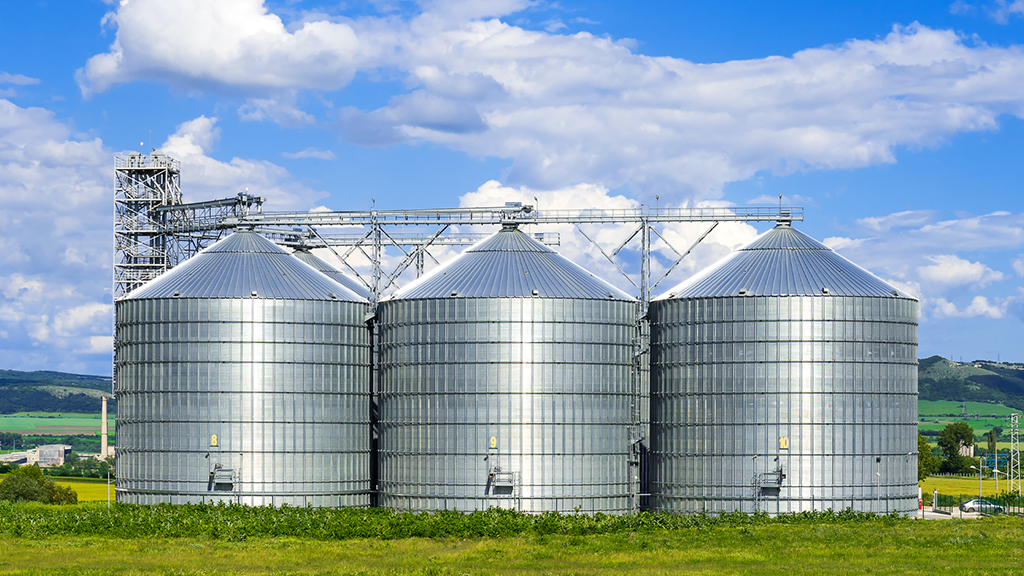 Three grain bins next to each other on a farm